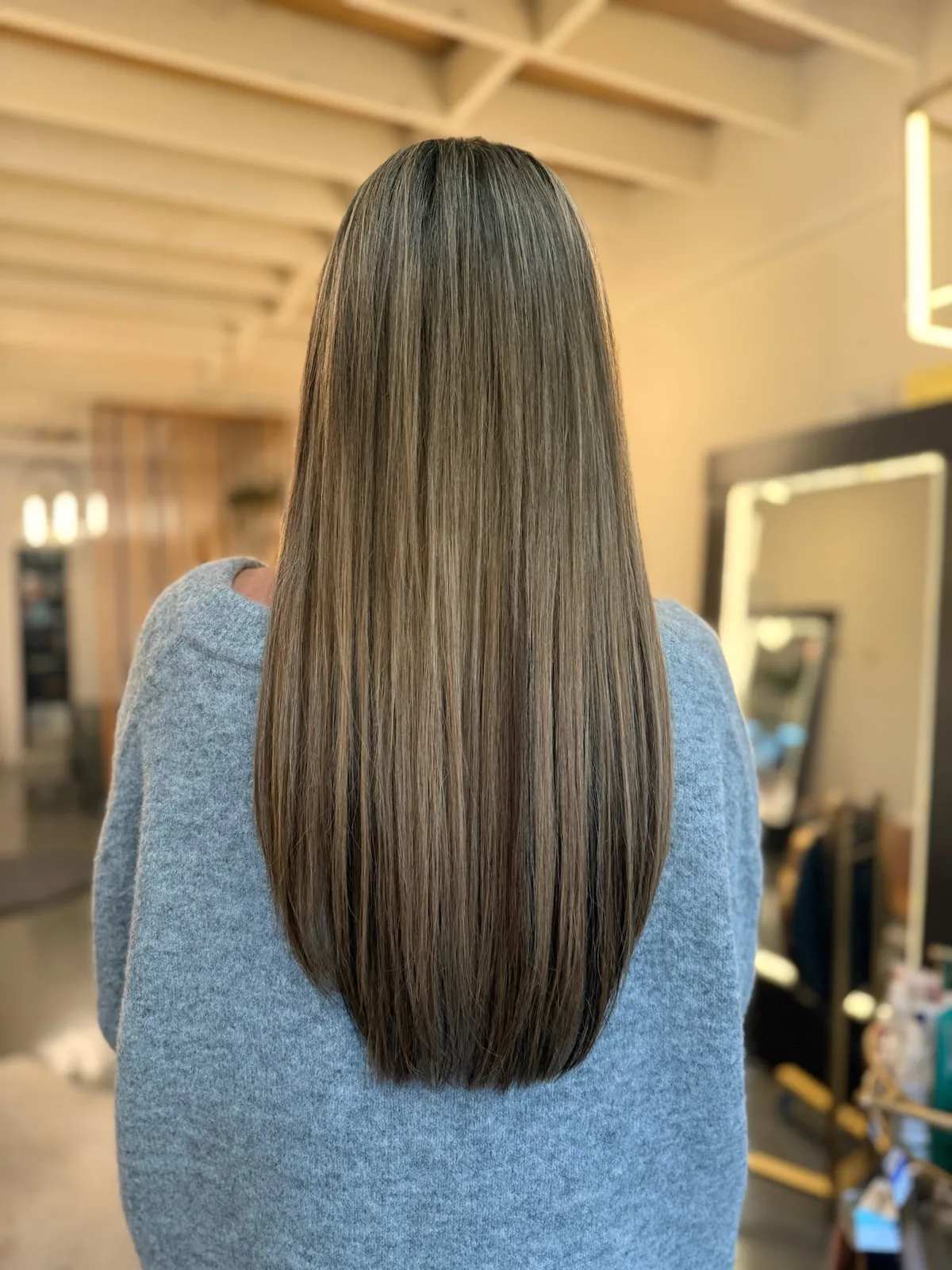 After: long straight highlighted hair.