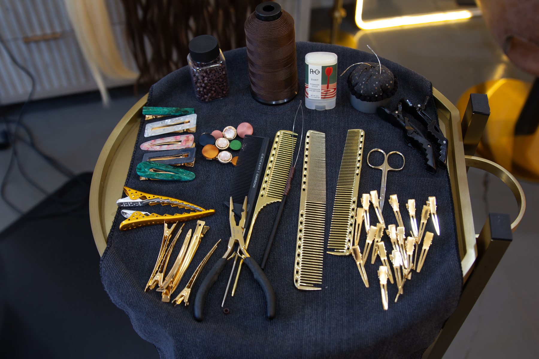 Gold shears, pliers and sectioning clips laid out on dark velvet.